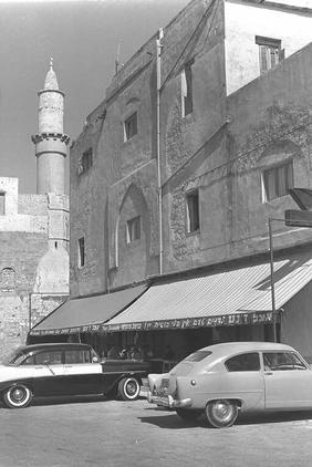Picture for Jaffa City: A LOOTED/STOLEN Apartment Building With a Mosque in the Background, 1961. Browse 70k pictures documenting Palestinian history & culture before Nakba